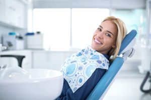 What does gum pain around a dental bridge suggest?